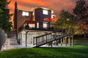 Twilight exterior of a two-storey detached home with landscaped front yard and double garage.