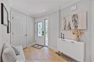 Welcoming front foyer with double-door entry, console table, and light wood flooring.