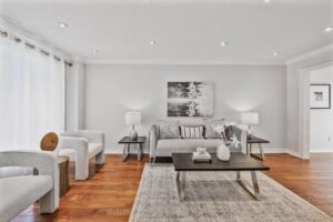 Bright living room with hardwood flooring, neutral décor, and large front window.