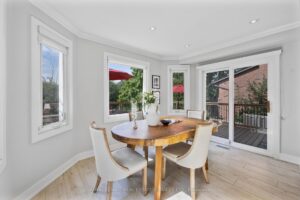 Breakfast area with bay window, round dining table, and walkout to the deck.
