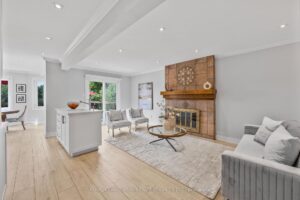 Family room with brick fireplace, light flooring, and large backyard-facing window.