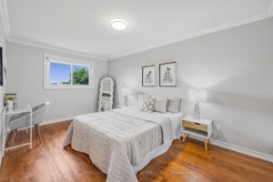 Bright secondary bedroom with hardwood flooring, large window, and neutral décor.