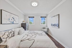 Bright bedroom with hardwood flooring, large window, and soft neutral finishes.