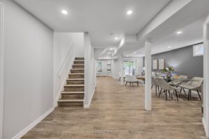 Finished basement with open recreation space, staircase, and dining area.