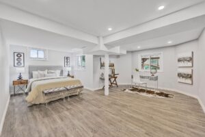 Finished basement recreation room with open layout, modern flooring, and recessed lighting.