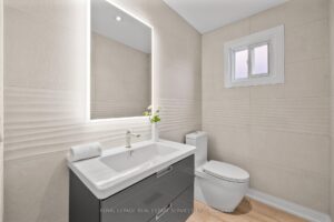 Modern powder room with floating vanity, large mirror, and bright window.