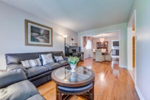 Living room with hardwood flooring and open view toward the dining room and foyer.