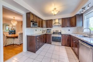 Spacious kitchen with tile flooring, granite countertops, and abundant workspace.