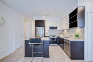 Modern kitchen with stainless steel appliances, centre island, and light flooring.