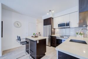 Bright kitchen with centre island, stainless steel appliances, and adjoining dining nook.