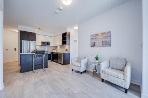 Open-concept kitchen and living area with centre island and modern seating.