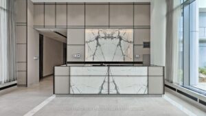 Concierge desk with marble-look feature wall and modern lobby design.