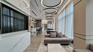 Modern amenity lounge with media wall, kitchenette, and contemporary seating.