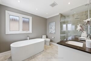Spa-inspired primary ensuite with freestanding soaker tub, glass shower, and double vanity.