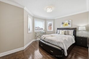 Bright secondary bedroom with hardwood flooring, large window, and neutral décor.
