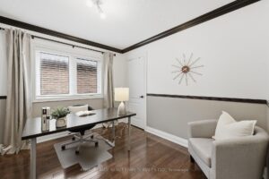 Home office with spacious work area, hardwood flooring, and abundant natural light.