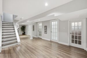 Finished basement recreation room with luxury vinyl flooring, recessed lighting, and flexible living space.