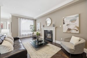 Comfortable family room with gas fireplace, large window, and hardwood flooring.