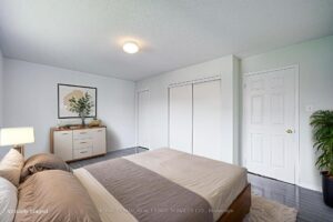 Bright bedroom with double closet and contemporary neutral finishes.
