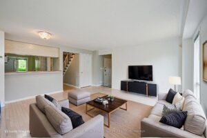 Living room with open-concept layout overlooking the kitchen and front entry.