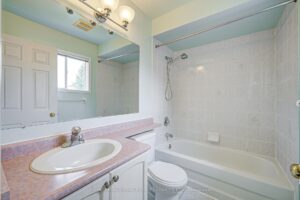 Four-piece bathroom with vanity, bathtub, and bright window.