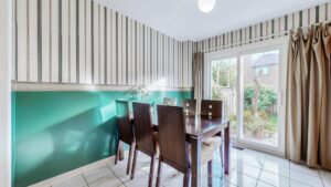 Bright dining room with patio doors overlooking the private backyard.