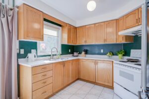 Bright kitchen with ample cabinetry, tile flooring, and stainless steel appliances.