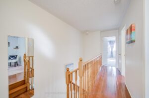 Second-floor hallway with hardwood flooring and natural light.