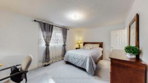Primary bedroom featuring generous space, large window, and soft neutral finishes.