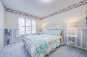 Bright secondary bedroom with large windows, plush carpeting, and calming décor.