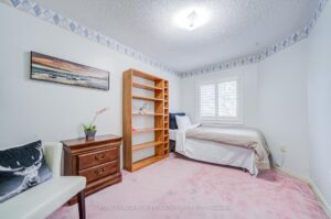 Third bedroom with large window, neutral finishes, and versatile layout.