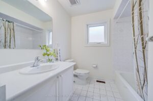 Four-piece bathroom with oversized vanity, bathtub, and tiled shower surround.