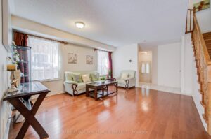 Open-concept living room with staircase and seamless flow to the dining area.