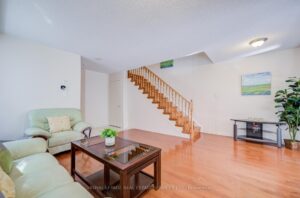 Living room with hardwood flooring overlooking the staircase and open main floor.