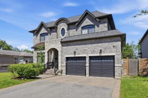 Angled front view of the luxury home with interlock walkway, landscaped gardens, and mature trees.
