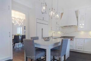 Open-concept dining area with large windows, modern lighting, and adjoining living space.